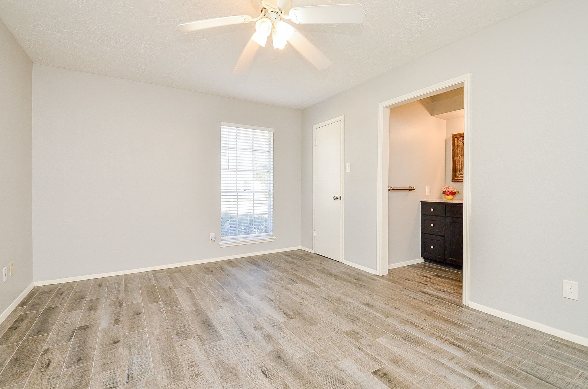 9215 Sharpcrest Street Houston, TX 77036 - Photo 14 of 31 wooden floor in an empty room with a window