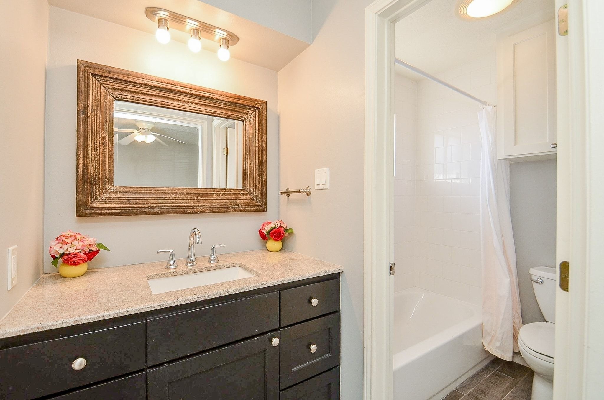 9215 Sharpcrest Street Houston, TX 77036 - Photo 16 of 31 a bathroom with a sink vanity mirror and toilet