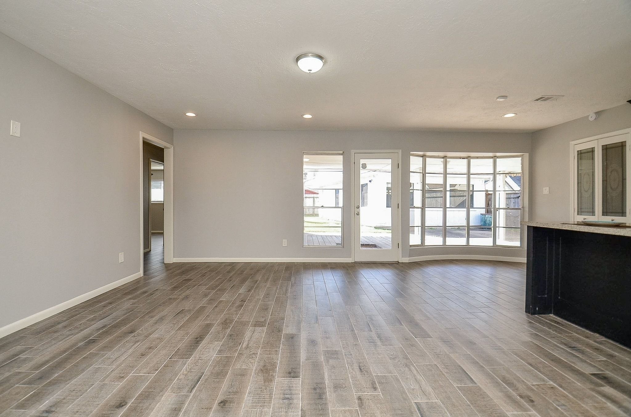 9215 Sharpcrest Street Houston, TX 77036 - Photo 2 of 31 wooden floor in an empty room with a window