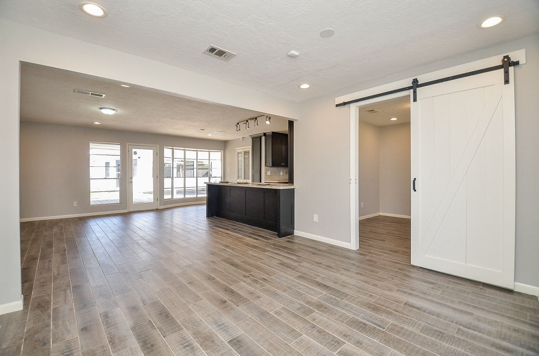 9215 Sharpcrest Street Houston, TX 77036 - Photo 3 of 31 a view of an empty room with wooden floor and a window