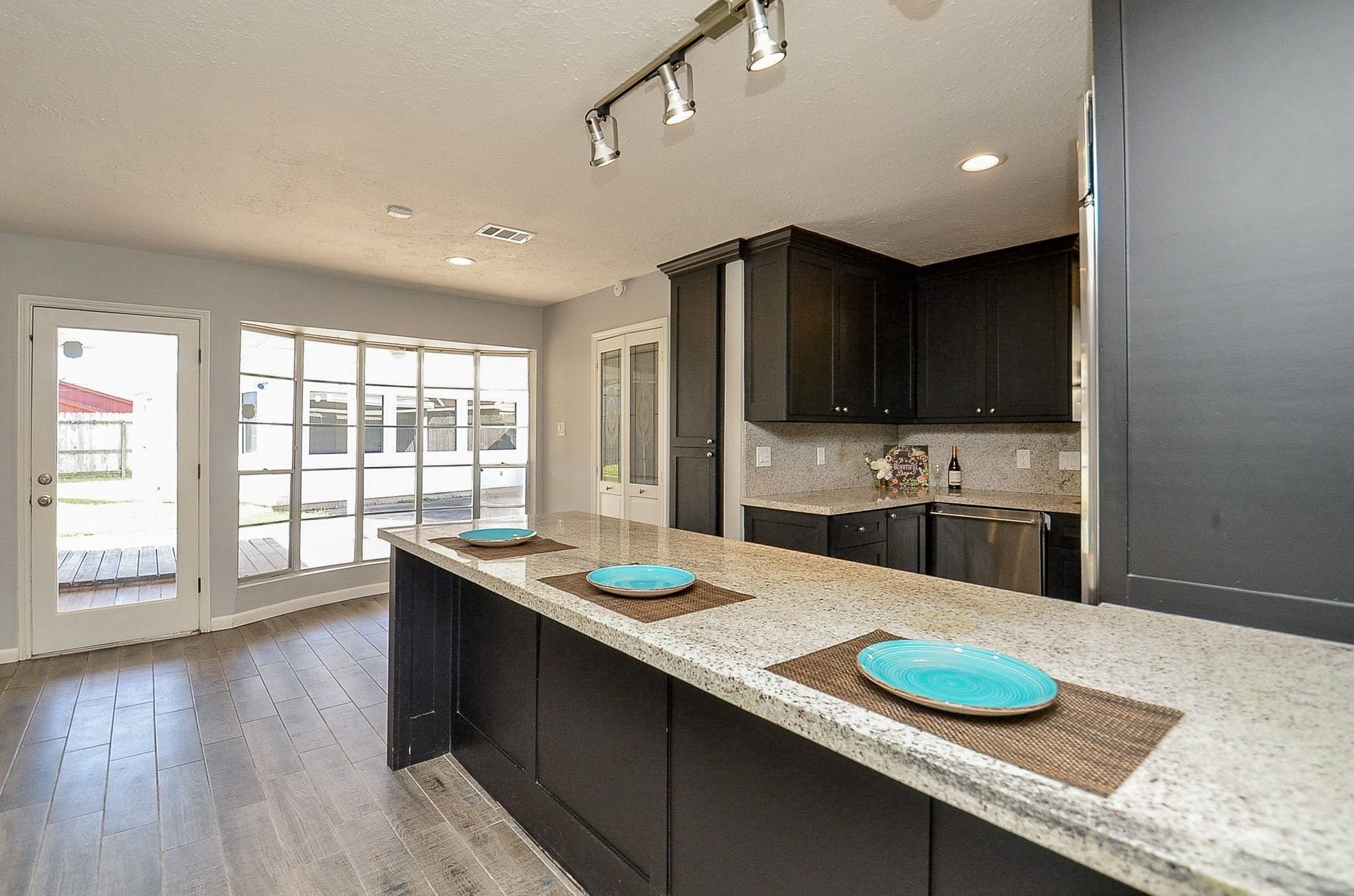 9215 Sharpcrest Street Houston, TX 77036 - Photo 8 of 31 a kitchen with kitchen island granite countertop a sink a counter space appliances and cabinets