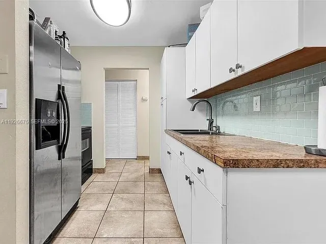 a kitchen with stainless steel appliances granite countertop a sink and a refrigerator