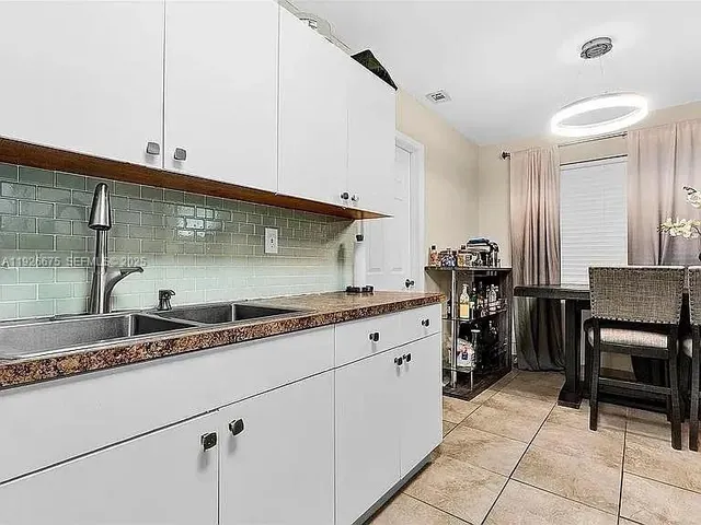 a kitchen with granite countertop a sink and cabinets