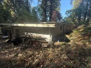 a backyard of a house with table and chairs under an umbrella