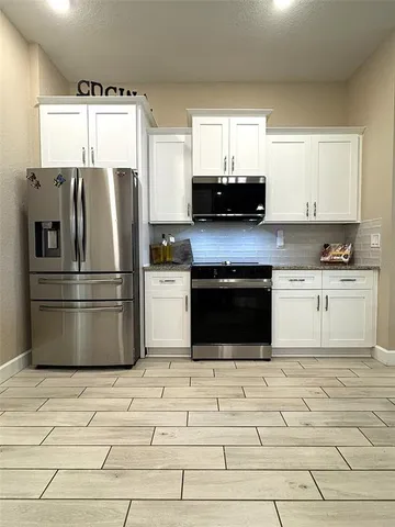 a kitchen with a cabinets and steel stainless steel appliances