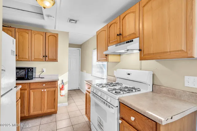a kitchen with a stove a sink and a refrigerator