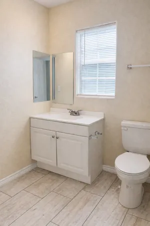 a bathroom with a sink toilet and window