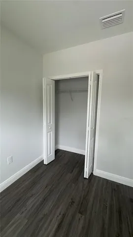 an empty room with wooden floor and closet