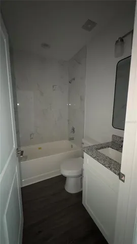 a bathroom with a granite countertop sink toilet and bathtub