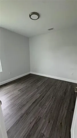 a view of a room with wooden floor and white walls