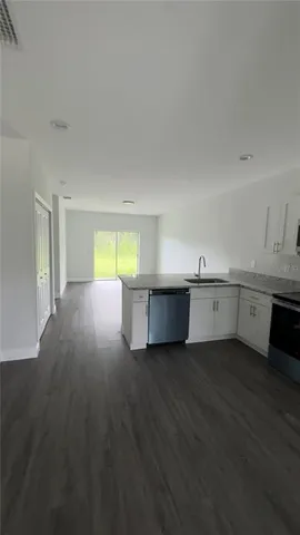 a view of a kitchen with wooden floor and windows