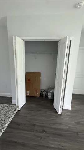 an empty room with wooden floor and closet