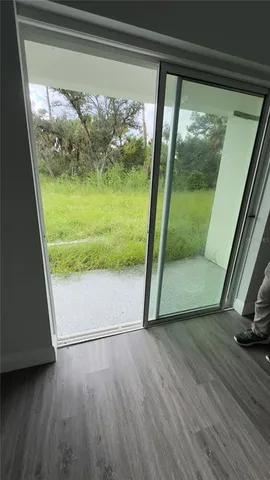 a view of a room with wooden floor and a window