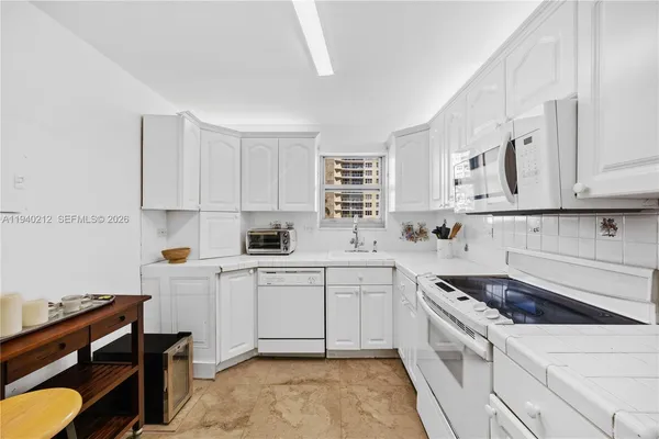 a kitchen with cabinets appliances a sink and a counter top space