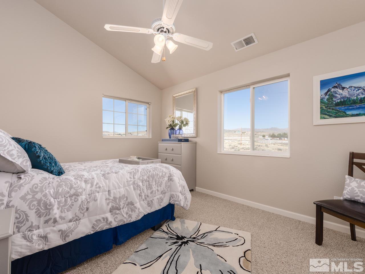 10315 Placerville Road Reno, NV 89508 - Photo 14 of 25 a bedroom with a large bed and a chandelier