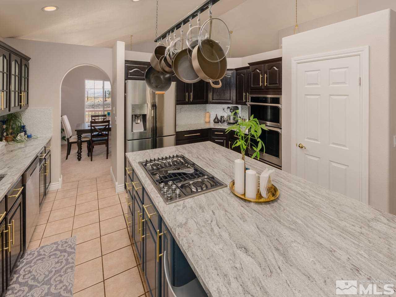 10315 Placerville Road Reno, NV 89508 - Photo 7 of 25 a kitchen with stainless steel appliances granite countertop a stove a sink dishwasher and cabinets with wooden floor