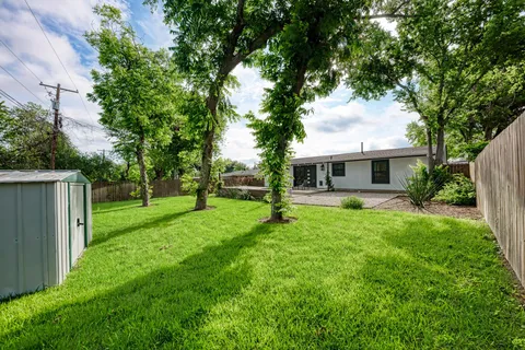 a view of a house with backyard and a tree