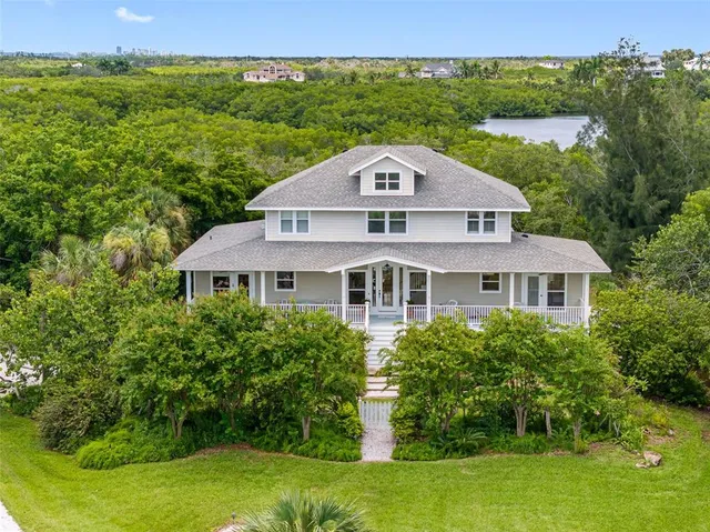a view of a big house with a big yard and large trees