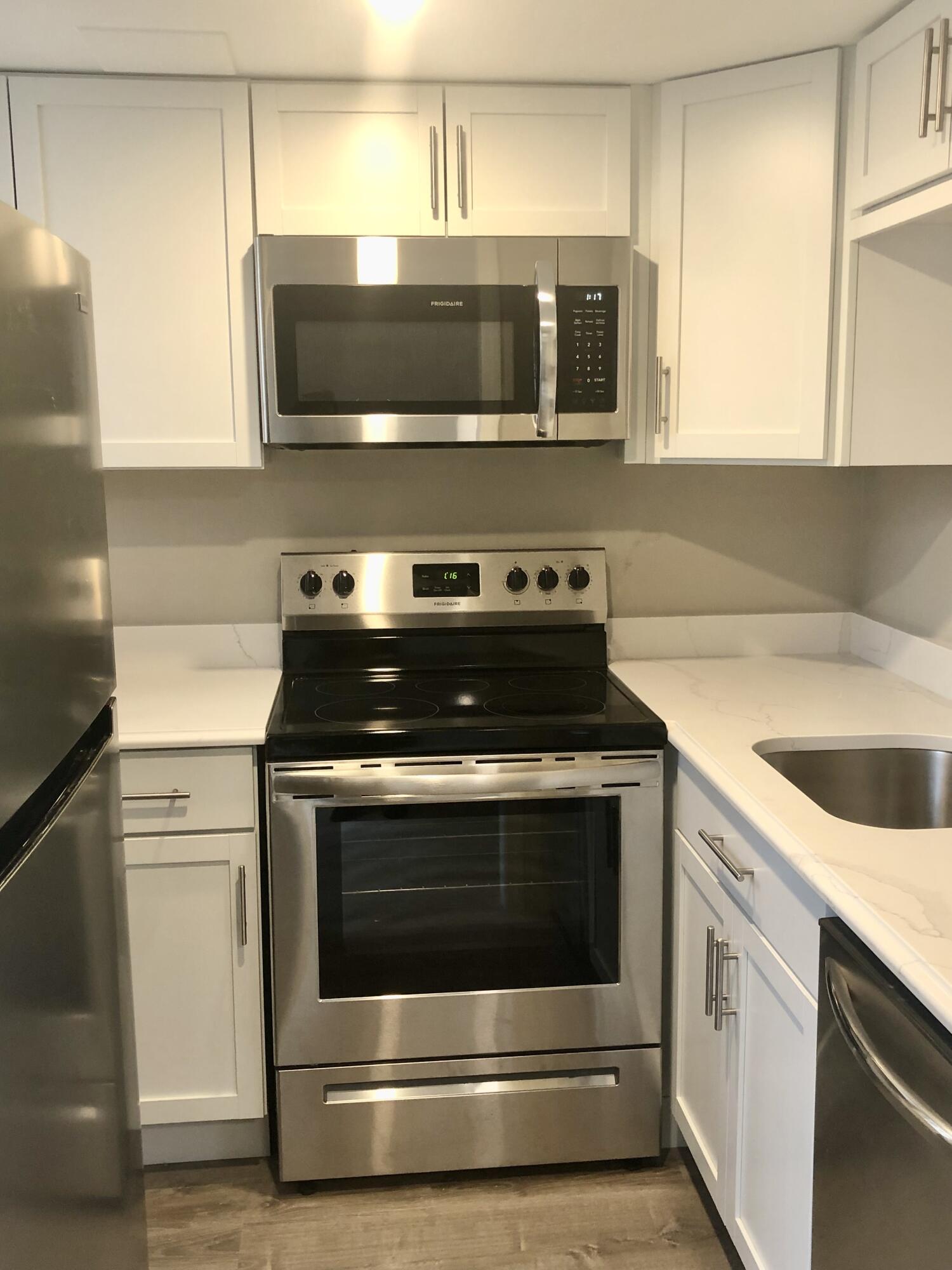 135 West Main Street, Unit 26 Hyannis, MA 02601 - Photo 12 of 29 a kitchen with stainless steel appliances a stove a microwave sink and cabinets