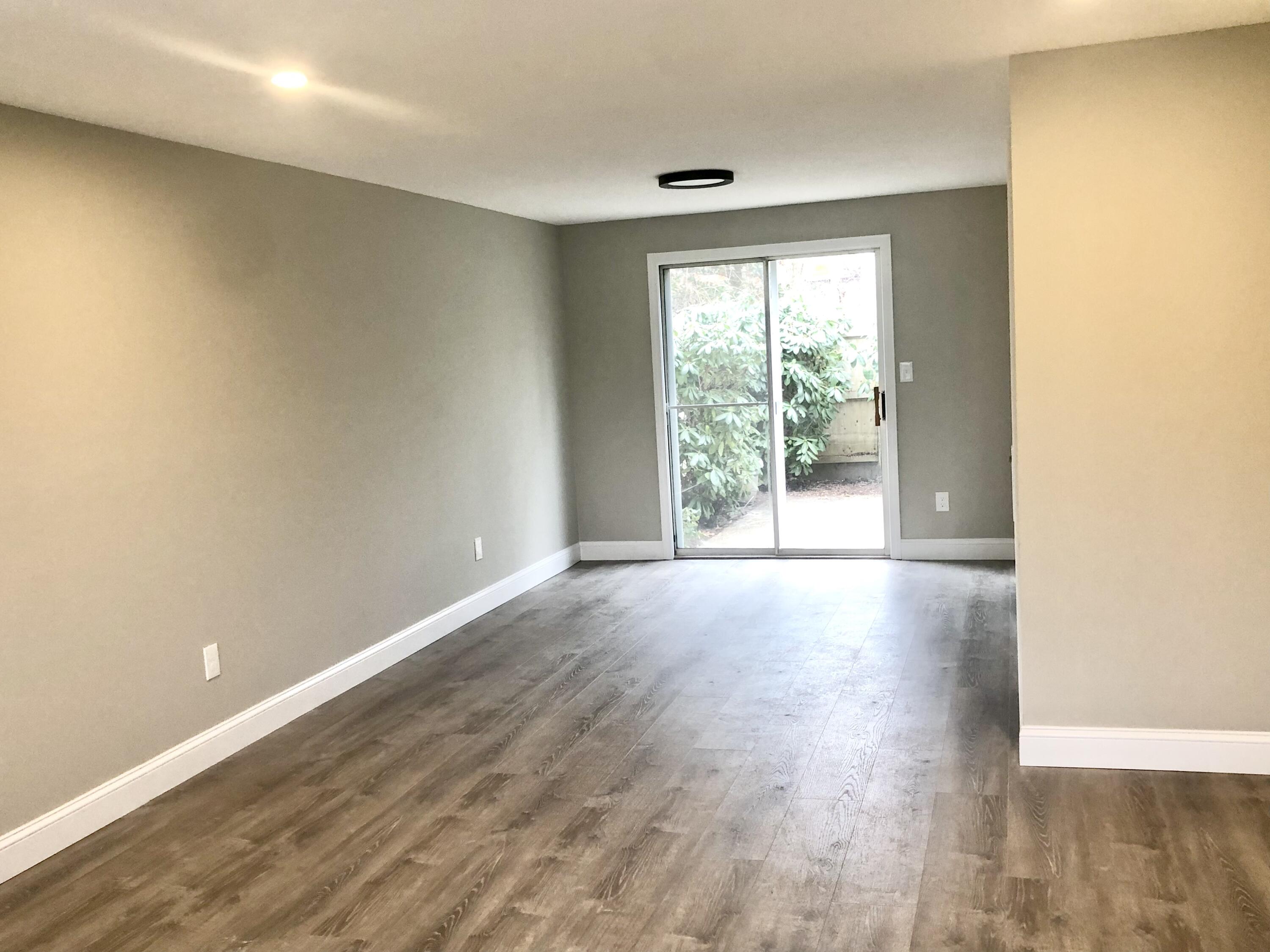 135 West Main Street, Unit 26 Hyannis, MA 02601 - Photo 5 of 29 an empty room with wooden floor and windows