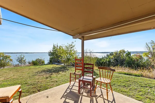 a view of a patio with a table chairs fire pit and a big yard
