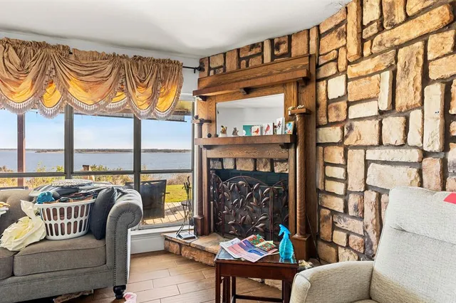 a living room with furniture a fireplace and a floor to ceiling window