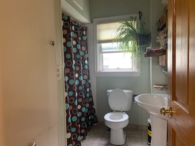 1013 Guion Street Ottawa, IL 61350 - Photo 10 of 26 a white toilet sitting next to a window and a shower