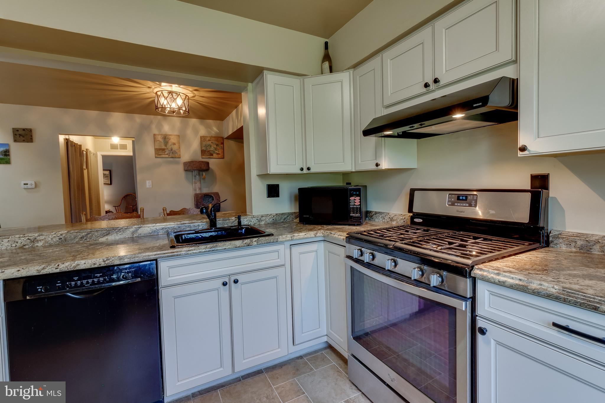 a kitchen with granite countertop stainless steel appliances and white cabinets