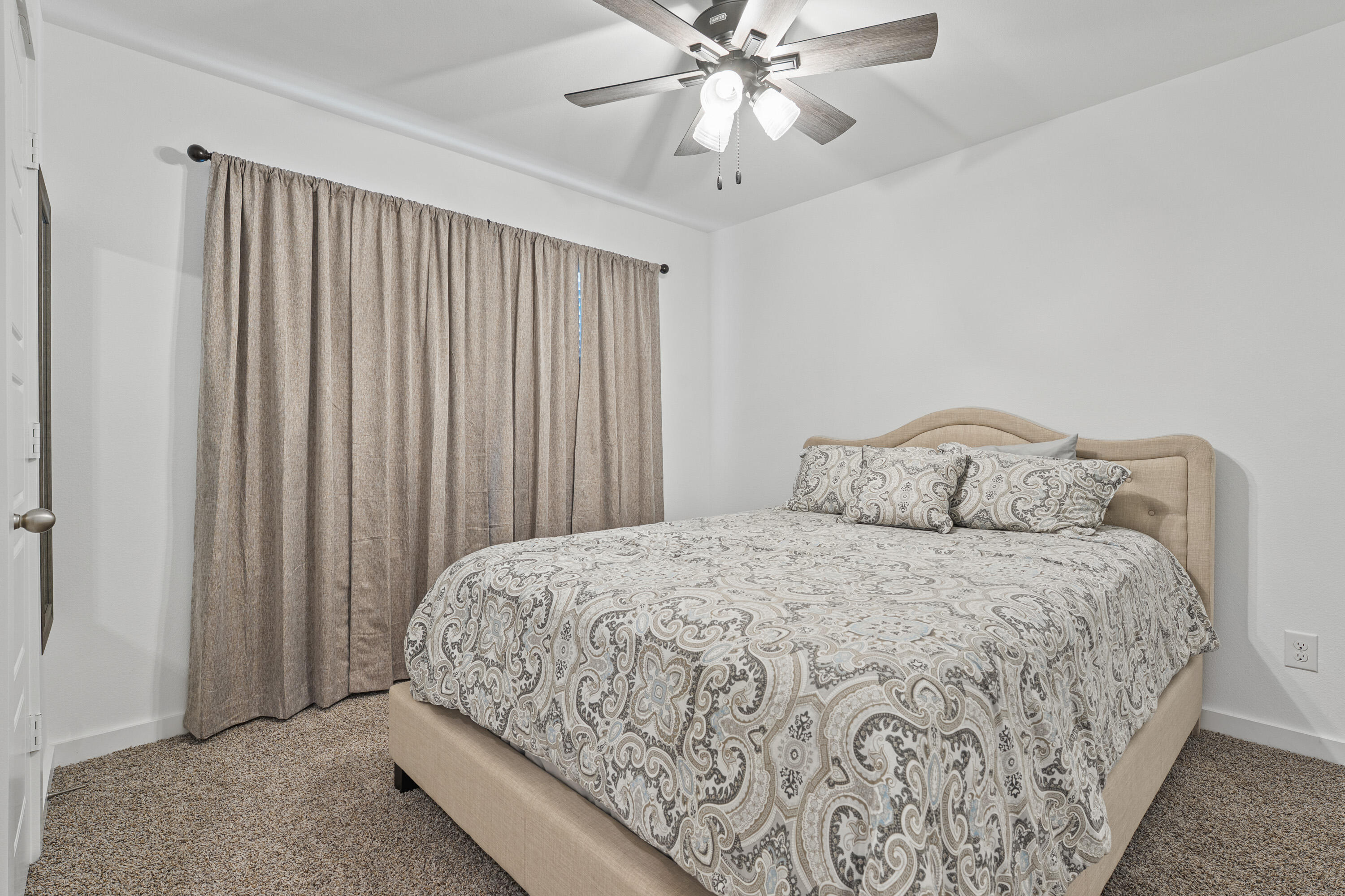10517 Bangor Avenue Lubbock, TX 79424 - Photo 20 of 27 a bedroom with a bed and a chandelier