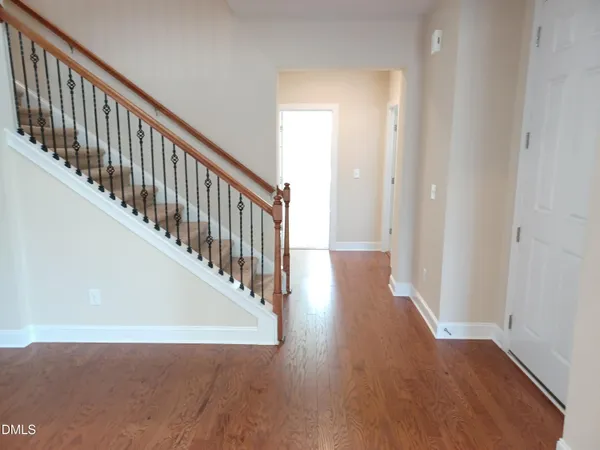 a view of a hallway with wooden floor and staircase