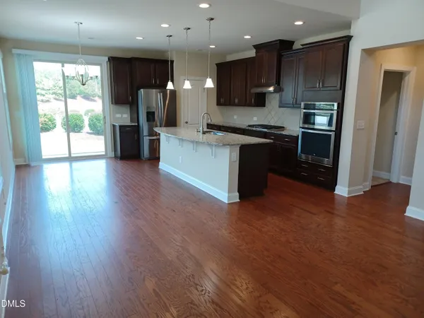 a large kitchen with stainless steel appliances granite countertop a large counter top a refrigerator and a stove