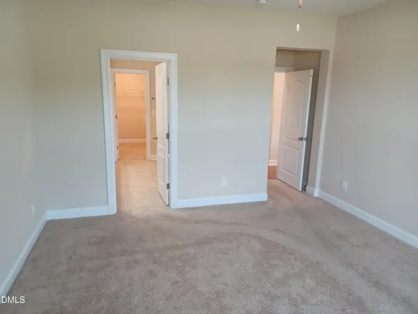 an empty room with closet and a bathroom