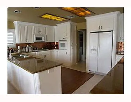 a kitchen with stainless steel appliances granite countertop a sink refrigerator and cabinets
