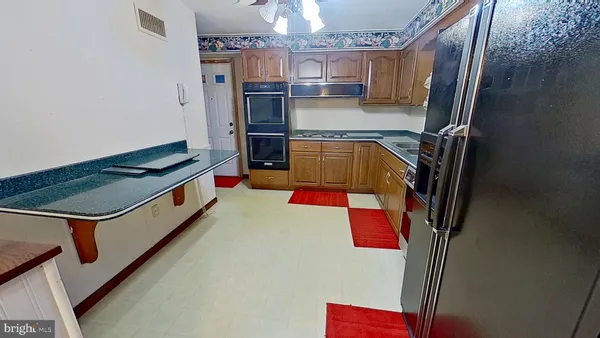 a kitchen with stainless steel appliances granite countertop a refrigerator and a stove