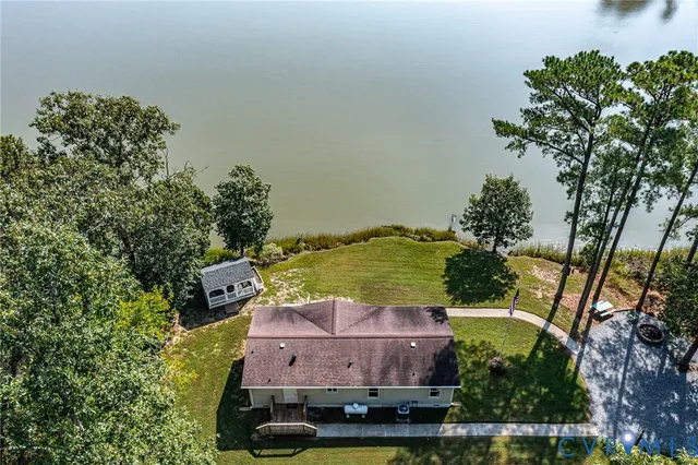 an aerial view of a house with a garden and lake view
