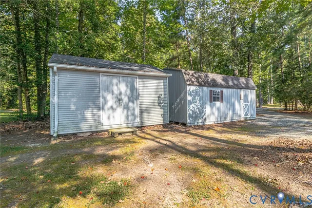 a backyard of a house with large trees and wooden fence