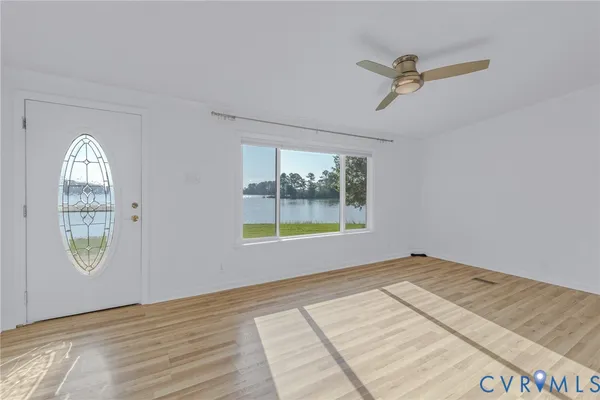 a view of an empty room with window and mirror