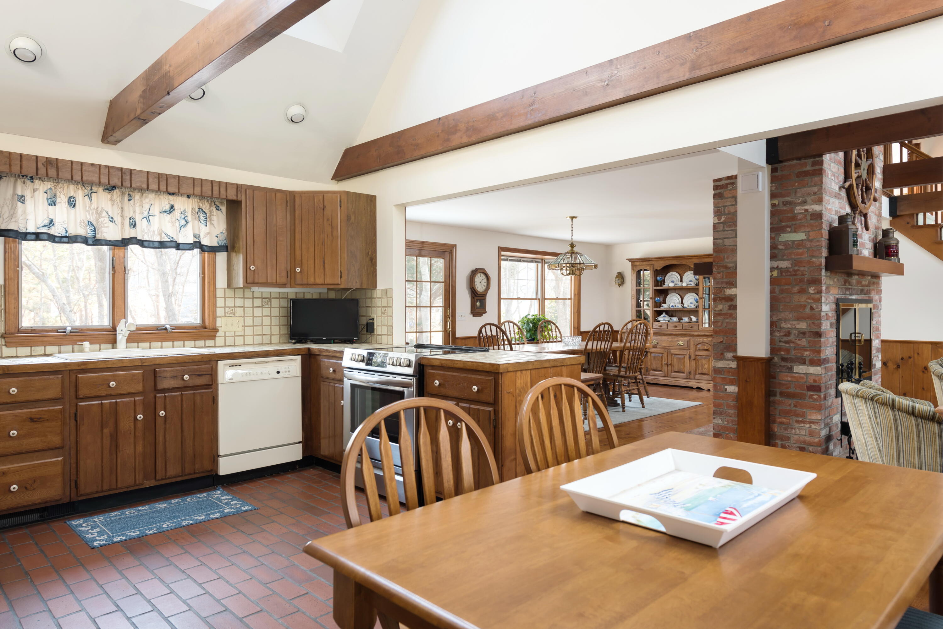 1 Wequasset Road Harwich Port, MA 02646 - Photo 14 of 25 a kitchen with stainless steel appliances granite countertop a stove top oven a sink a dining table and chairs with wooden floor