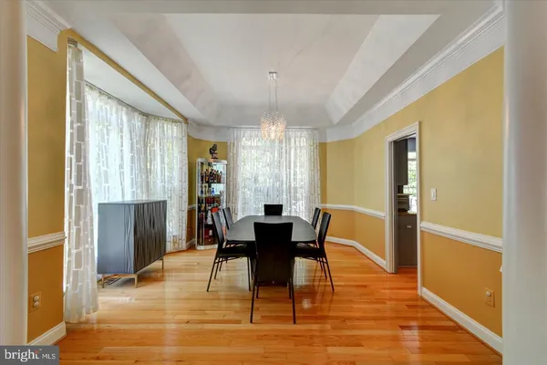 a dining room with furniture a chandelier and wooden floor