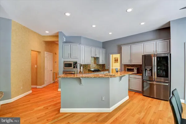 a kitchen with stainless steel appliances granite countertop a refrigerator a stove top oven a sink and dishwasher
