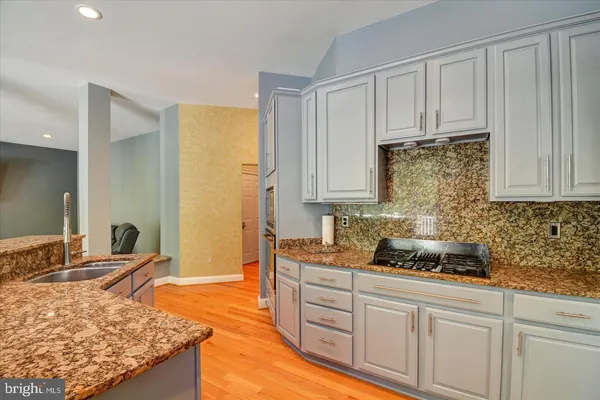 a kitchen with stainless steel appliances granite countertop a sink stove and cabinets