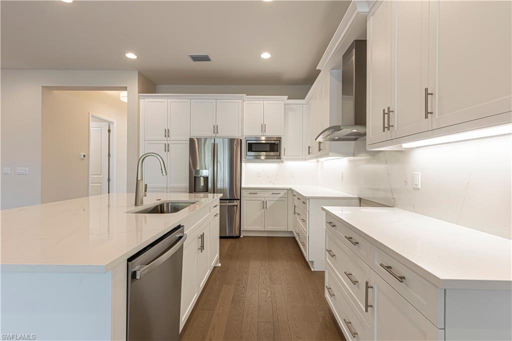 2691 Ridgecrest Place Naples, FL 34112 - Photo 12 of 27 a kitchen with a sink a stove and cabinets