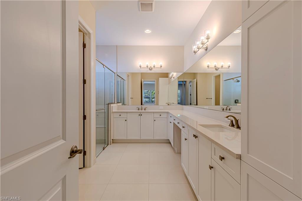 2691 Ridgecrest Place Naples, FL 34112 - Photo 18 of 27 a large bathroom with a double vanity sink mirror and bathtub