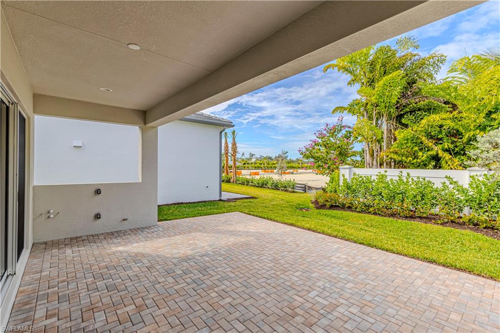 2691 Ridgecrest Place Naples, FL 34112 - Photo 22 of 27 a view of an empty room with a garden and trees