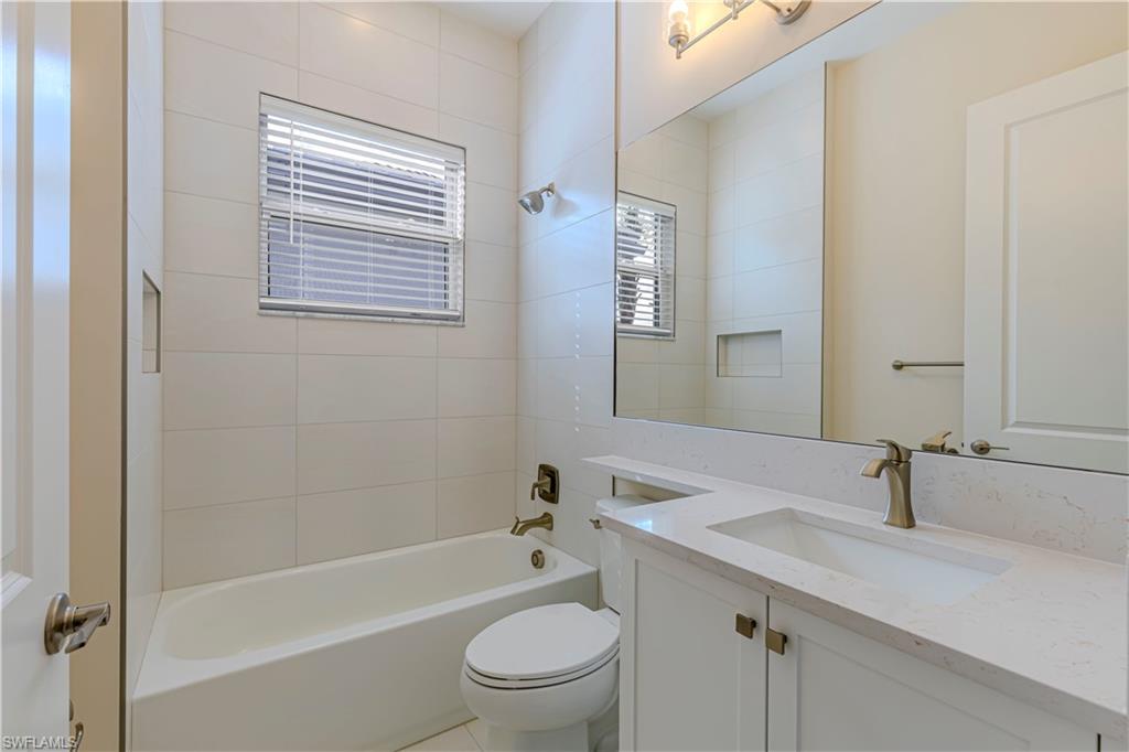 2691 Ridgecrest Place Naples, FL 34112 - Photo 7 of 27 a bathroom with a granite countertop sink toilet and shower