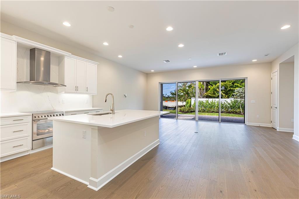 2691 Ridgecrest Place Naples, FL 34112 - Photo 10 of 27 a large kitchen with stainless steel appliances granite countertop a lot of counter space and wooden floors