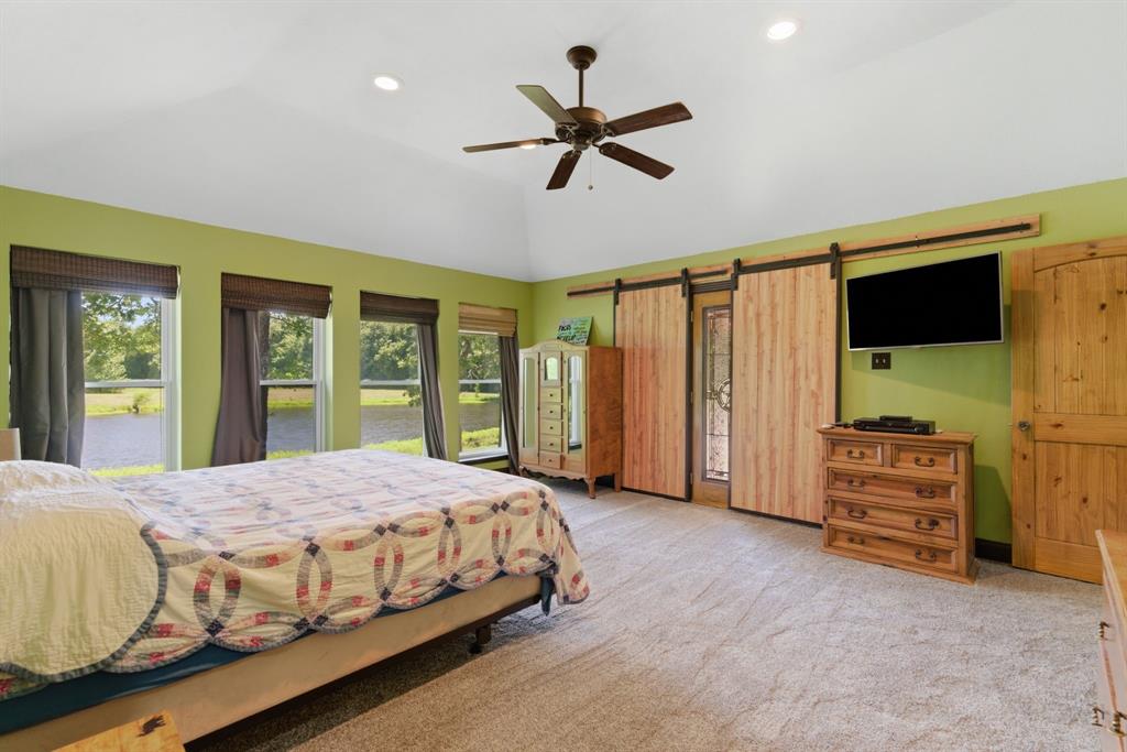 321 Cr 211 Road Gainesville, TX 76240 - Photo 18 of 40 Plenty of natural light in the primary with rustic barn doors covering the entry to the back patio,