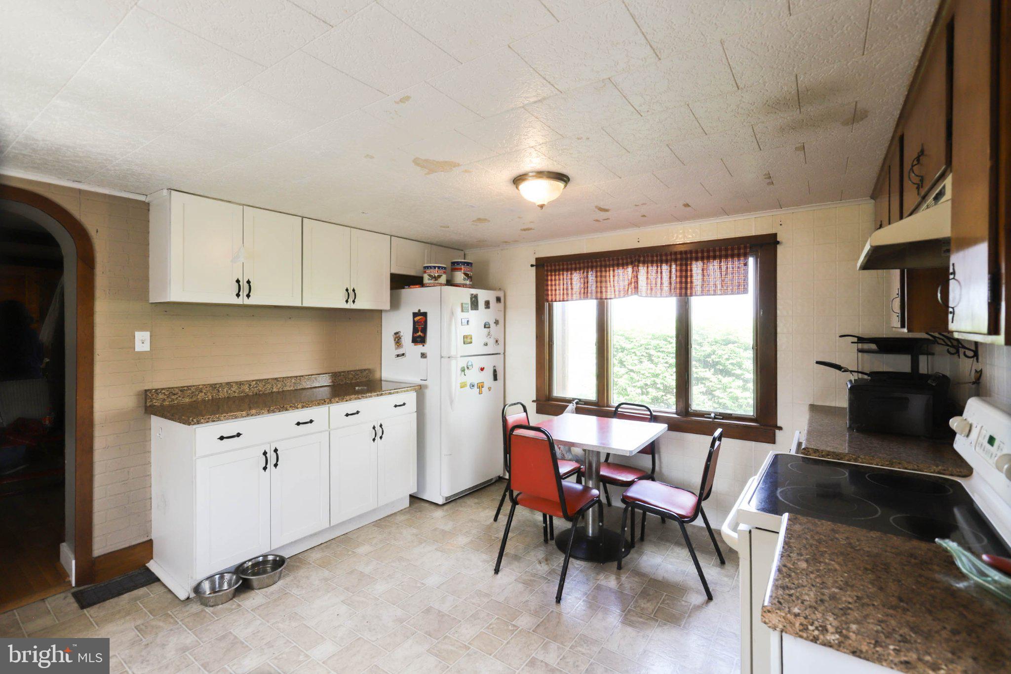 11661 Tanyard Hill Road Orrstown, PA 17244 - Photo 8 of 26 a kitchen with granite countertop a stove a sink dishwasher a dining table and chairs with wooden floor