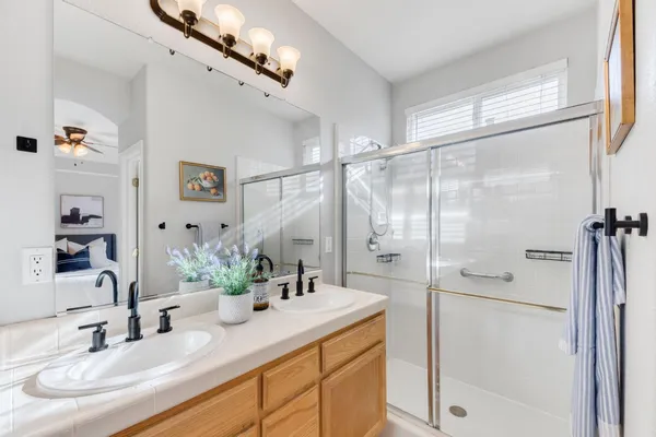 a bathroom with a granite countertop sink mirror and a shower