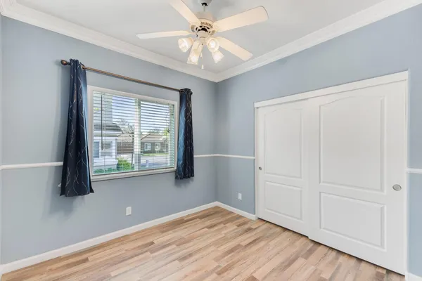 a view of an empty room with a window and wooden floor